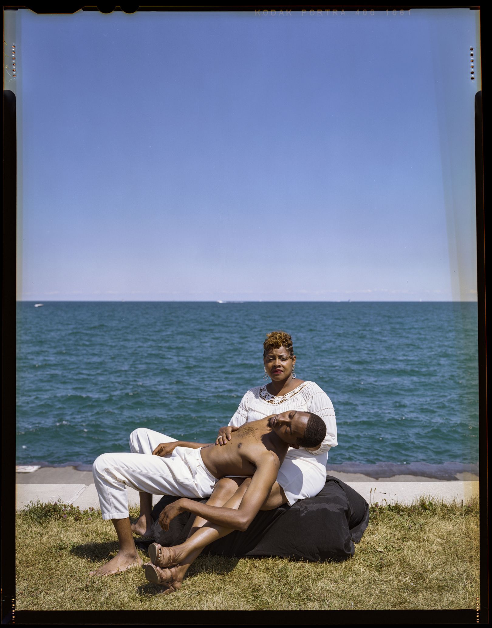 Mother holding adult son, strung over her lap.