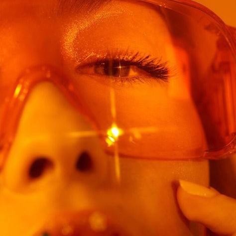 Up close shot of a woman's orange sunglasses.
