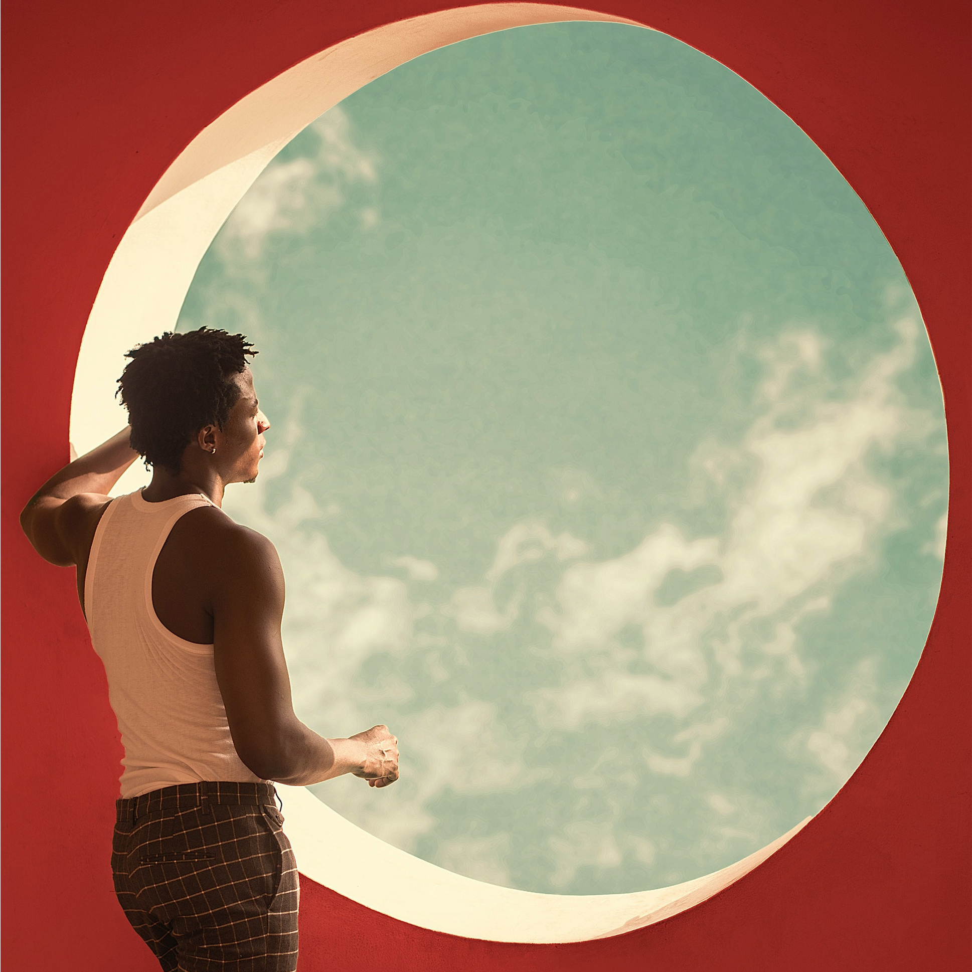 Man staring out through circular sky window.