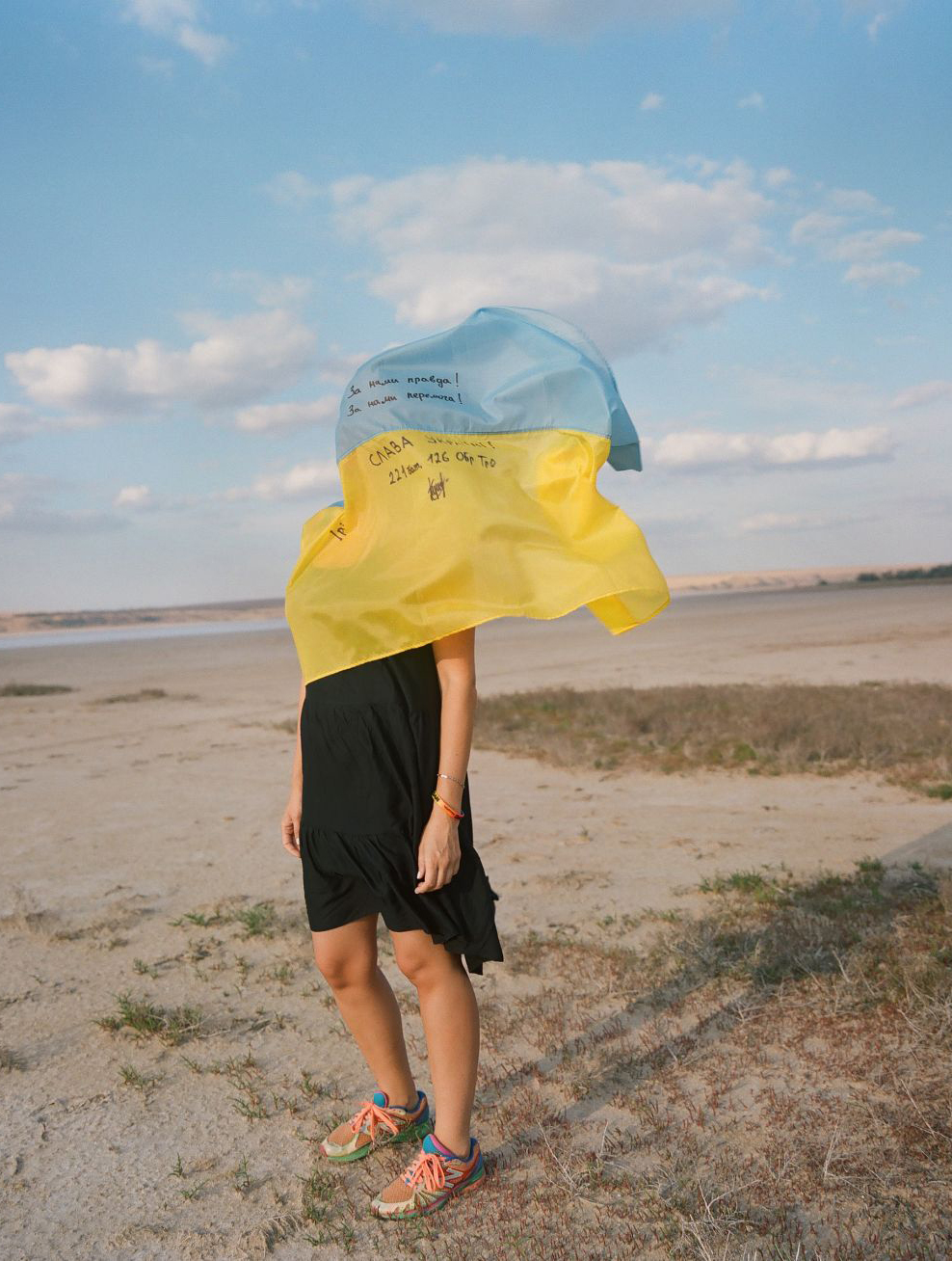 Woman covered by Ukrainian flag.