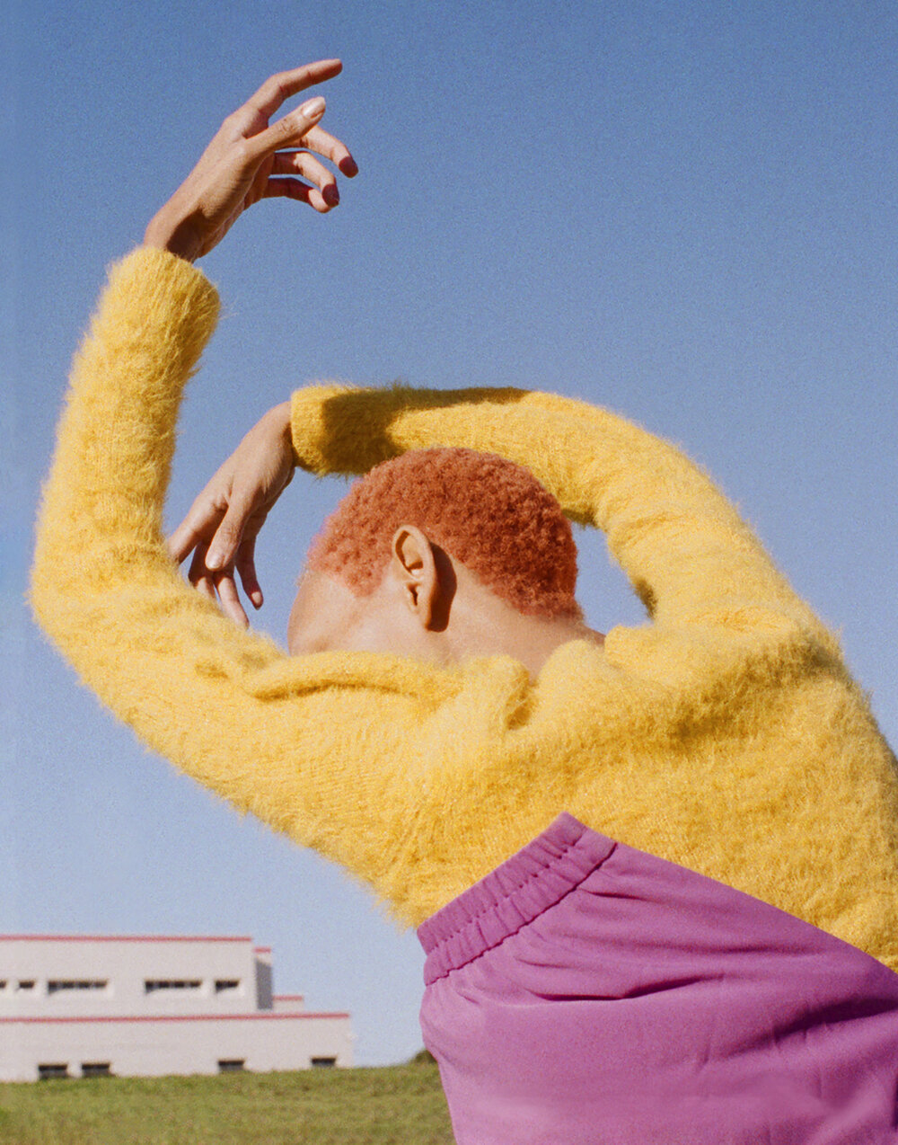Colorful photograph of woman with hands stretched above her body.