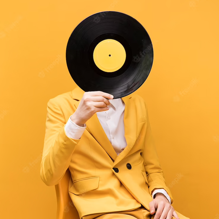 Man in all yellow holding a vinyl record over his head.